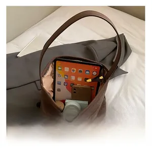 Detailed view of brown woven tote bag interior showing capacity for tablet and phone