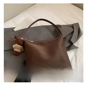 Detail showing coffee brown woven PU hobo bag with a cute rabbit plush charm
