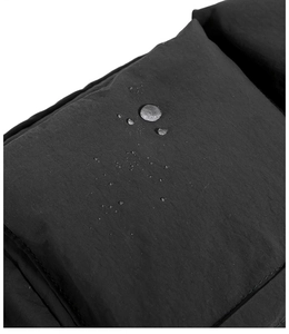 Dettaglio del tessuto in nylon nero con gocce d'acqua che mostrano il materiale impermeabile