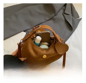 Interior view of brown suede crescent bag showing space for phone and cosmetics
