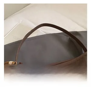 Detailed view of woven leather tote bag texture with cute teddy bear charm