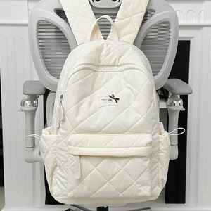 Detailaufnahme des cremefarbenen Stepprucksacks mit Rautenmuster und Schleifendetail