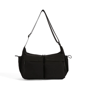 Dettaglio borsa tote in nylon nero con doppie tasche frontali e lacci laterali regolabili