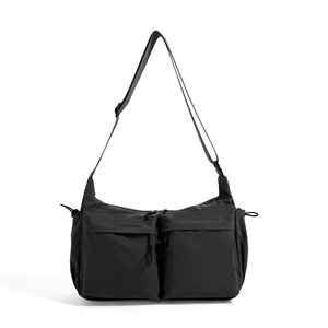 Dettagli di una borsa a tracolla in nylon nero impermeabile con doppie tasche anteriori