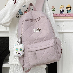Detail eines lavendelfarbenen Stepprucksacks mit Rautenmuster und süßem Katzenplüschtier