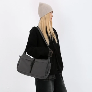 Vista dettagliata della borsa a tracolla in nylon grigio scuro con due tasche frontali