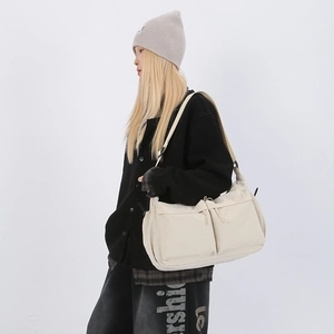 Dettaglio della borsa tote in nylon bianco sporco con due tasche e tracolla regolabile