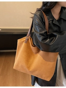 Grand sac cabas minimaliste en daim marron porté par un mannequin de mode