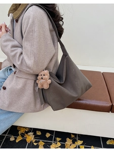 Dettaglio della trama della borsa hobo in ecopelle grigio scuro con ciondolo a orsetto