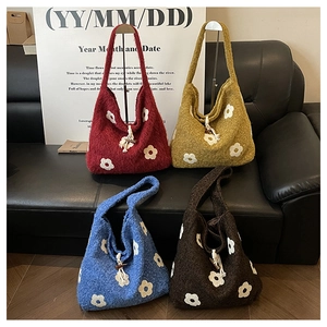 Detailed shot of knitted floral tote bags in four colors with wooden button closures