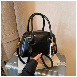 Detail of black Boston bag with Chic'zao logo, bead charm and retro gold hardware