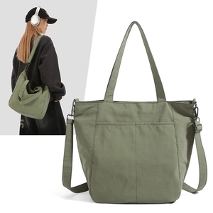 Detail view of olive green nylon tote bag with stitching and adjustable shoulder straps