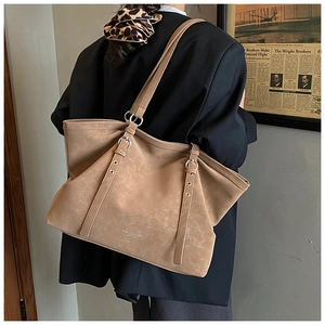 Macro view of textured khaki leather tote with silver buckle and fashion engraving