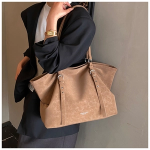 Close-up of retro brown tote bag with matte leather texture and adjustable shoulder straps