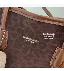 Macro view of vintage brown leopard print tote bag with soft suede texture and fluffy pompom