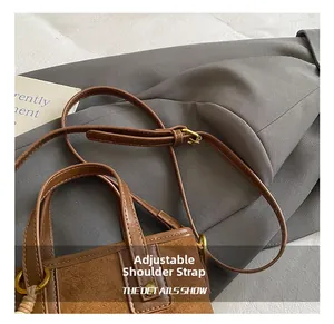 Detail showing adjustable leather shoulder strap and brass hardware on vintage bucket bag