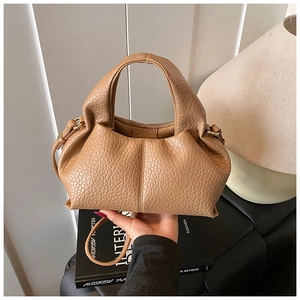 Detailed texture of khaki textured leather on a cloud-shaped handbag with thin shoulder strap