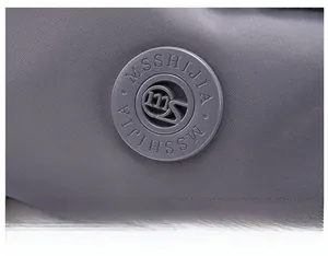 Detailed macro view of the grey water-resistant nylon fabric and brand logo on the bag