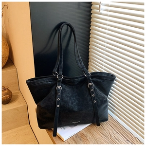Gros plan détaillé du sac cabas vintage noir avec œillets métalliques et bandoulière