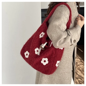 Detail of red plush floral tote bag showing soft fur texture and white cotton drawstring