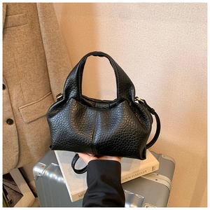 Detail of black cloud bag featuring textured PU leather and elegant gold hardware