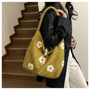 Detail of hobo bag in mustard yellow fleece with white floral pattern and toggle button