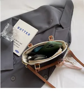 Interior view of contrast color bucket bag showing storage for phone and cosmetics