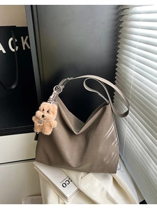 Dettaglio della grande borsa hobo marrone scuro con ciondolo a forma di cane in peluche