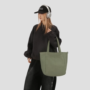 Detail view of olive green large capacity tote bag with practical front outer pocket