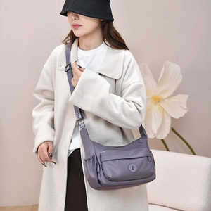 Detail view of water-resistant nylon crossbody bag with multi-pockets and logo strap