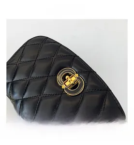 Gros plan du fermoir en métal doré et des coutures matelassées du sac en cuir noir