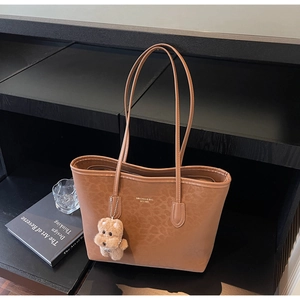 Detail of leopard print tote bag with brown puppy charm and MINIGUDI brand lettering