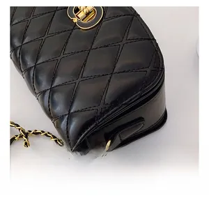 Gros plan sur un sac en cuir matelassé noir avec fermoir tournant CD doré