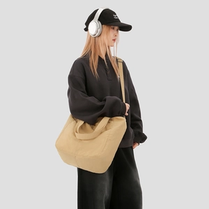 Close-up of a large khaki canvas tote bag with sturdy straps for daily commute