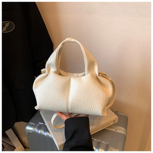 Close-up of cream white pleated leather bag showing soft texture and golden hardware