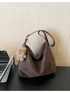 Dettaglio borsa tote in pelle testa di moro con trama morbida e ciondolo a forma di cucciolo