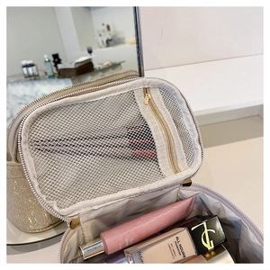 Dettaglio della borsa cosmetica con paillettes oro champagne e divisorio in rete