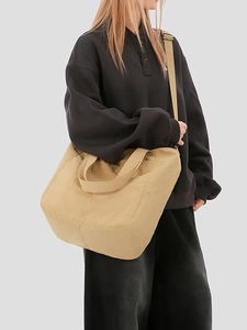 Minimalist khaki canvas tote bag with adjustable shoulder strap for daily commuting