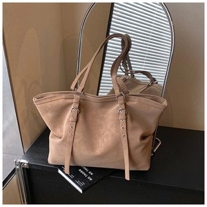 Détail du grand sac cabas en daim marron avec sangles à œillets métalliques et style minimaliste