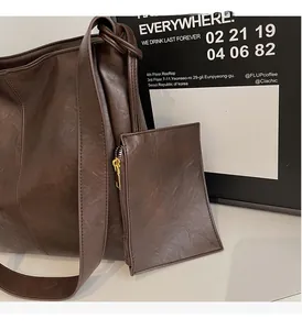 Detail of dark brown faux leather tote bag with detachable coin purse and gold hardware