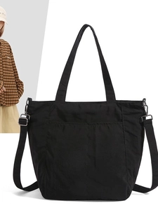Versatile black nylon tote bag with dual front pockets and adjustable shoulder strap