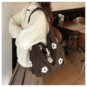 Close-up of brown plush tote bag featuring white flower appliques and wooden horn buckle