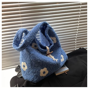 Detailed shot of blue plush tote bag with flower pattern and wooden horn buckle closure
