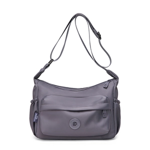 Detail showing the front zipper pocket and side drawstring pockets on a dark grey bag