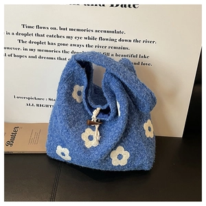 Detail of blue plush tote bag with white flower pattern and wooden toggle closure