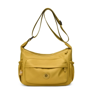 Close-up of waterproof yellow nylon crossbody bag with side pocket and logo detail