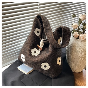 Detail of dark brown felt tote bag with white flower embroidery and wooden toggle closure