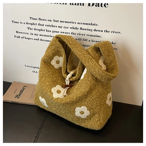 Detail of plush yellow tote with white flower pattern and wooden toggle closure