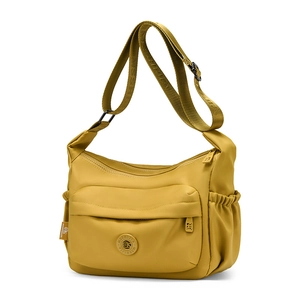 Detail of ginger yellow waterproof nylon crossbody bag with multi-pockets and wide strap