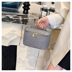 Dettaglio della borsa trucco con paillettes argento e doppia cerniera dorata